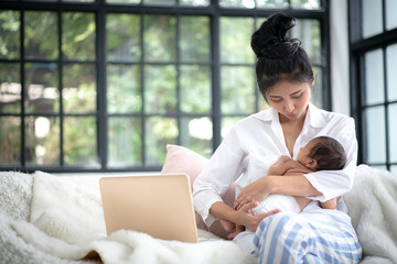 Adolescent mother is breastfeeding a baby.