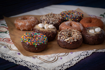 Beautiful doughnuts covered in chocolate glaze, sprinkles,  marshmallows and chopped nuts