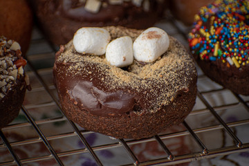 Chocolate glazed donut sprinklesd with cookie crumbs and mini marshmallows