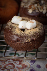 Chocolate glazed donut sprinklesd with cookie crumbs and mini marshmallows
