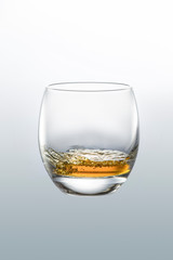 Glassware with whiskey on a neutral gray background. Close-up side view