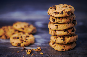 pile of chocolate cookies against wooden background with copy space