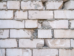 Low quality wall from white brick. Poor work. Close-up fragment