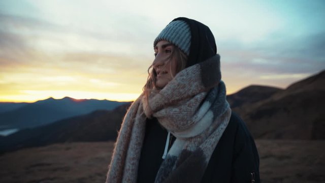 Close up view of stylish caucasian toung woman walks looks around enjoy the breathtaking view on mountain top trip travel nature outdoor sunrise tourist adventure landscape journay slow motion