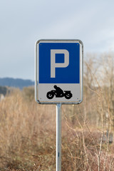 blue motorbike parking sign with black motorbike and white writing with large "P" on blue background