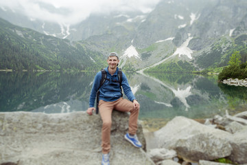 man relaxing on the lake and mountains sunny landscape