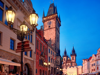 Prague, Old City Hall on the Town Square early evening with street lights. Historic architecture of houses and church of St. Mary before Tyn illuminated with sunset. Beautiful Prague on sunset.
