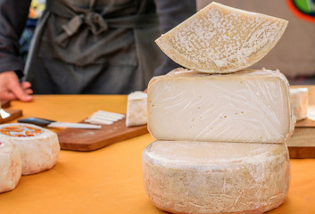 Some cheese heads and cheese cut on the table for saling at the market place one holiday.