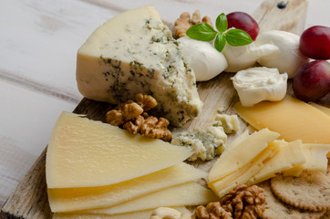 cheese plate on the white background with jam nuts and cookies