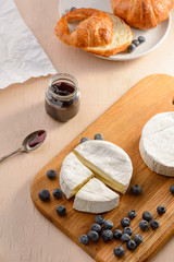 Brie cheese, blueberries and croissants on a table