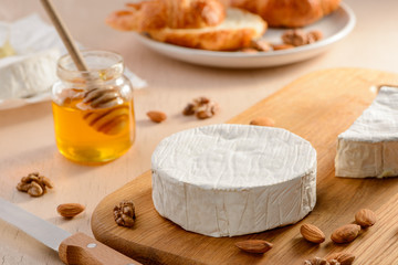 Camembert cheese with a beautiful white rind on a wooden cutting board