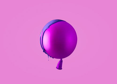 Helium balloon covered in blue paint on magenta background