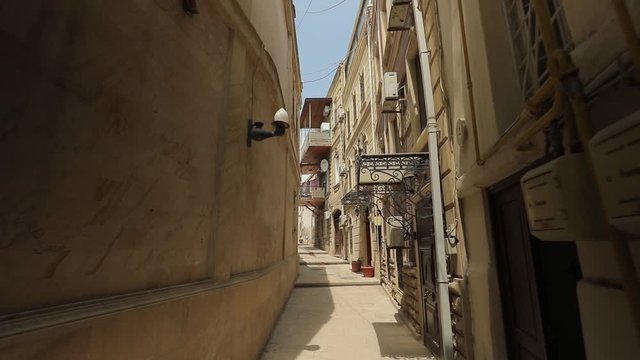 A small cozy narrow street in the historical center of Baku, Azerbaijan. The camera moves smoothly along the street, sunny summer day in a southern country