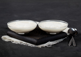 Vanilla Panna cotta in a glass dish, Italian dessert creamy jelly with coconut shavings on a dark...