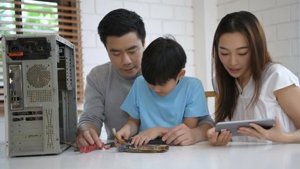 Family concept. Parents are encouraging their sons to learn to repair computers. 4k Resolution.