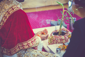 Indian hindu wedding and pre wedding ritual pooja items and hands close up