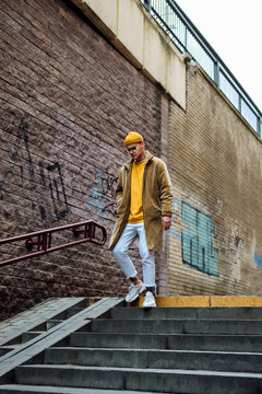 Photo of a young fashion stylish trendy look man model  in color clothes modern style outdoor street style  natural light