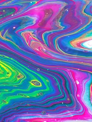 Vibrant neon green and neon pink dance with purple and blue in this swirling rainbow of color for backgrounds.