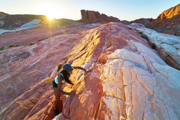 High angle view of female african american hiker climbing rock at Valley of Fire in nevada desert