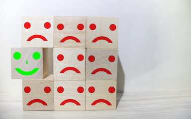 many cubes with smiling emoticons and one sad one standing out