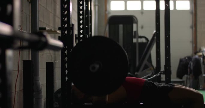 fit asian male benchpress at gym with camera dolly move