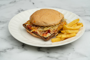 Hamburger with meat, tomato, lettuce and french fries.