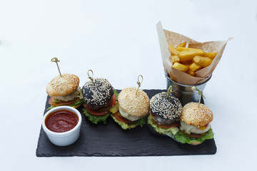 Sandwiches, french fries and sauce on a white dish. Restaurant serving.