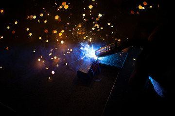 Metal welding. Sparks from electric heating. Work in the workshop. Creation of reliable fastening...