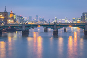 Fototapeta na wymiar Blue dawn morning lights and long exposure London Bridge cityscape on a cold winter December morning