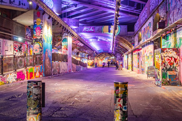 Purple lights and colorful street art murals at a London Graffiti Tunnel