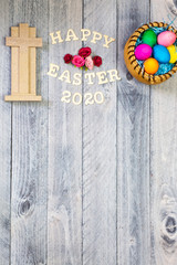 Cross, Easter eggs and happy Easter 2020 on a wood background