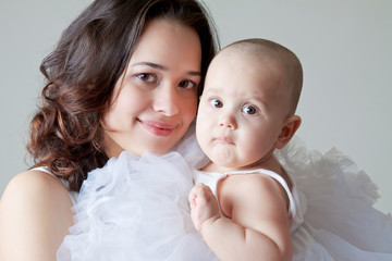 The happiness of motherhood. Mother holds a little white angel, her daughter, without hair