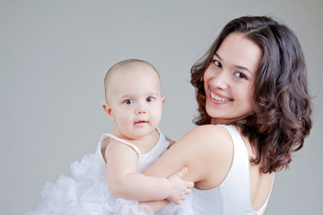 The happiness of motherhood. Mother holds a little white angel, her daughter, without hair