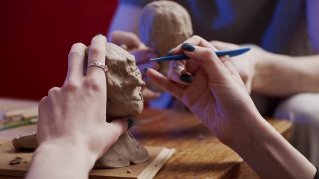 Two young artists sculpting using Plasticine (non-drying clay)
