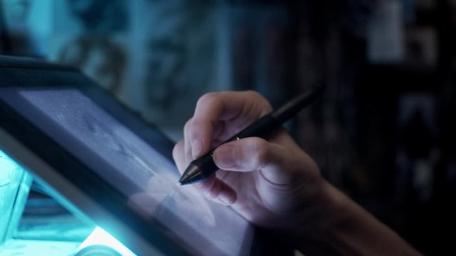 Young artist drawing illustration on tablet, slow motion, shallow depth of field