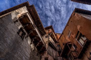 Fototapeta na wymiar Narrow medieval alley way with passage made of terracotta red stone in Albarracin Spain