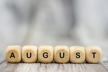 The word August on wooden cubes. Month of year