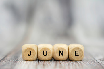 The word June on wooden cubes. Month of year