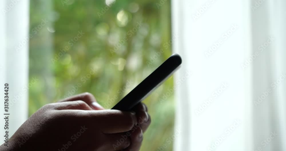 Aufkleber young man using smartphone with window background. chat and online shopping with smart phone