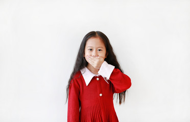 Portrait asian little girl in scarlet dress expression covering mouth with hand isolated on white...