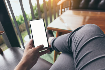 Mockup image blank white screen cell phone.man hand holding texting using mobile on desk at coffee shop.background empty space for advertise text.people contact marketing business,technology 
