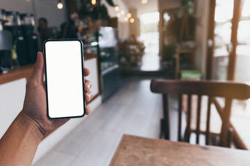 Mockup image blank white screen cell phone.man hand holding texting using mobile on desk at coffee shop.background empty space for advertise text.people contact marketing business,technology 