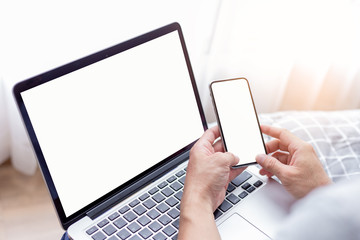 mockup image blank screen computer,cell phone with white background for advertising text,hand man using laptop texting mobile contact business search information on desk in cafe.marketing,design