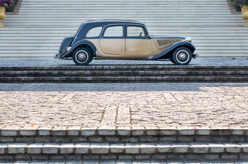 Vintage French Car in two toned black and gold isolated in Palatial setting on a grand staircase...