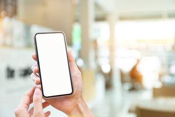 Mockup image blank white screen cell phone.man hand holding texting using mobile on desk at coffee shop.background empty space for advertise text.people contact marketing business,technology 