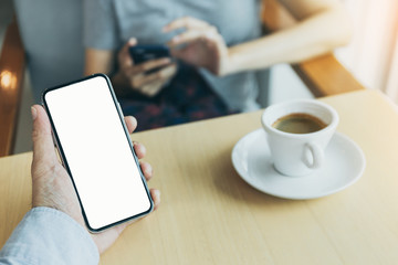 Mockup image blank white screen cell phone.man hand holding texting using mobile on desk at coffee shop.background empty space for advertise text.people contact marketing business,technology 