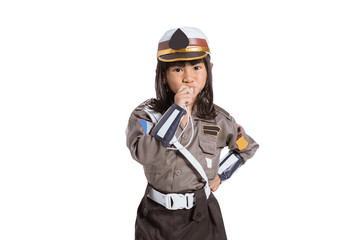 Fototapeta premium Asian little girl wearing a police uniform with a whistle blowing on an isolated background