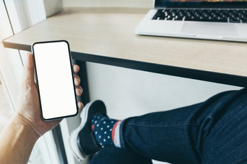 Mockup image blank white screen cell phone.man hand holding texting using mobile on desk at coffee shop.background empty space for advertise text.people contact marketing business,technology 