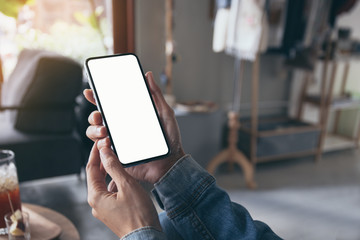 Mockup image blank white screen cell phone.man hand holding texting using mobile on desk at coffee shop.background empty space for advertise text.people contact marketing business,technology 