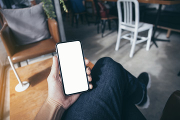 Mockup image blank white screen cell phone.man hand holding texting using mobile on desk at coffee shop.background empty space for advertise text.people contact marketing business,technology 